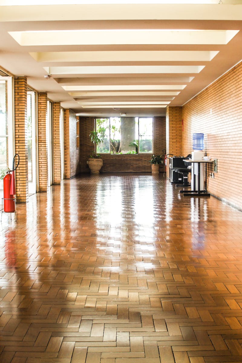 Empty brick corridor in Sé, São Paulo with polished floors and natural light.