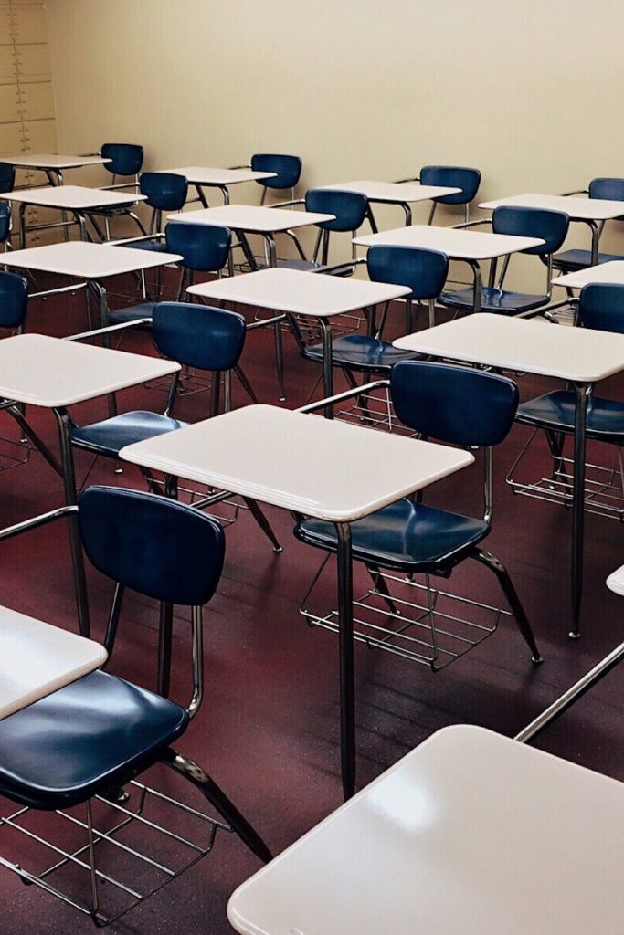 An indoor view of a modern, clean classroom with rows of empty desks and chairs.